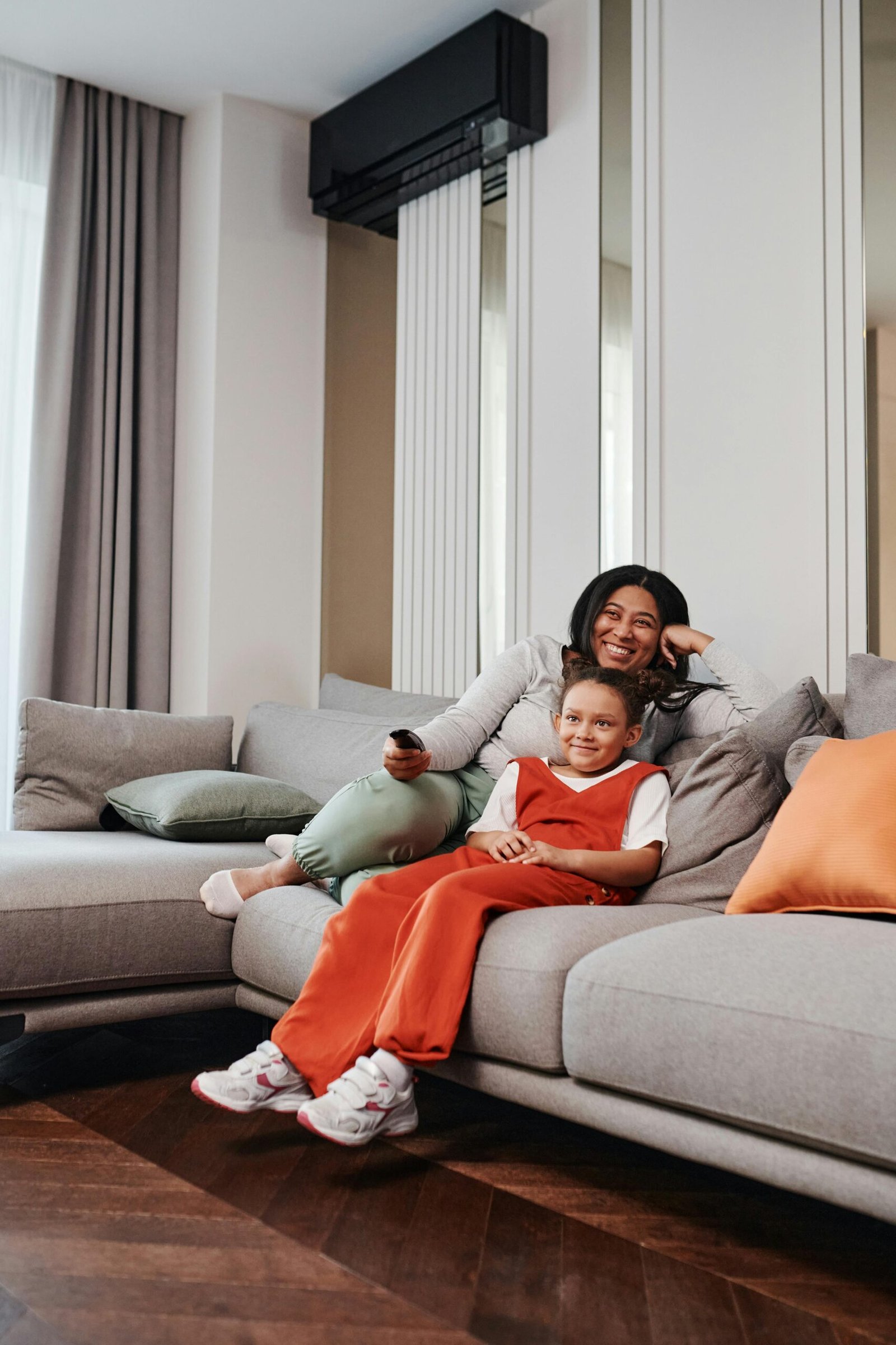 pexels-photo-8259524-8259524 A mother and daughter enjoy a cozy moment on a modern living room sofa, sharing quality time together.